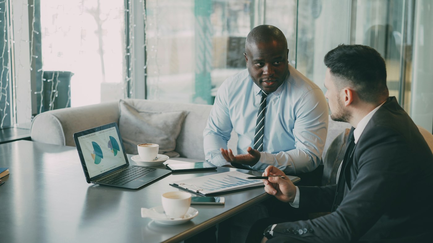 Two colleagues reviewing business charts on a laptop